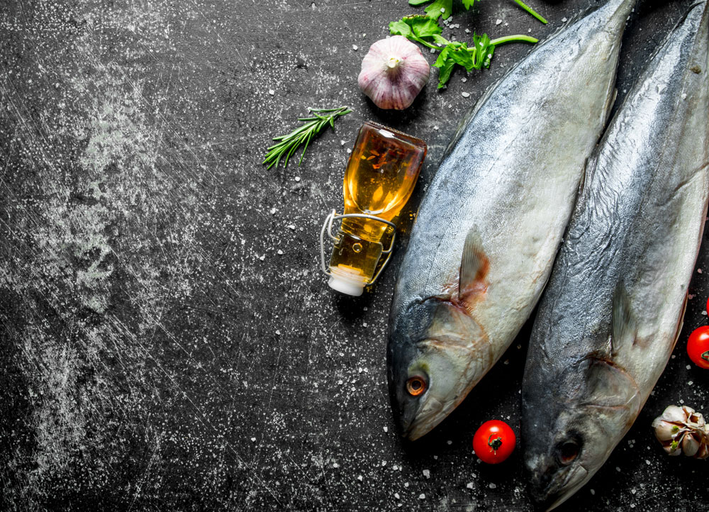 生の魚とトマトの枝の野菜と油の小