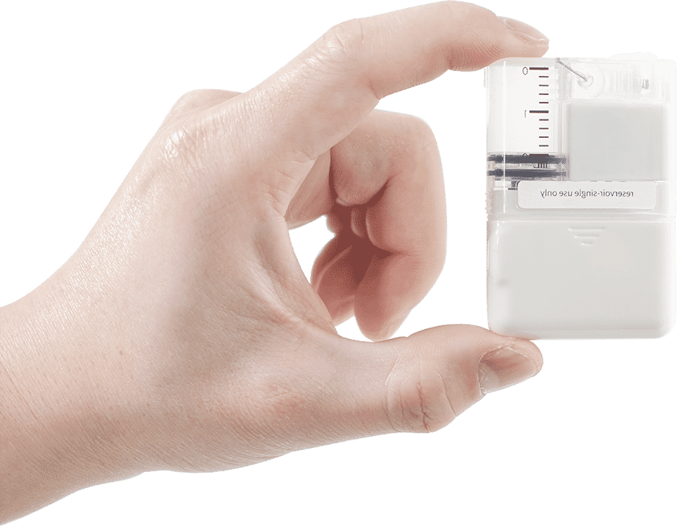 A hand holding up a small device known as a tubeless insulin pump.